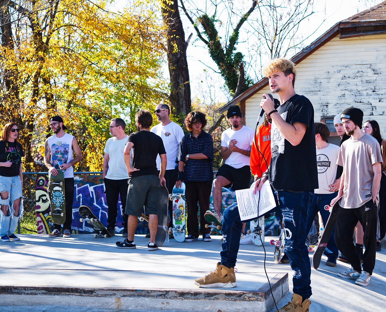 Nathan Witt, flanked by skaters from near and far, addresses the gathered crowd before commemorating the Iron Horse Skate Park with a follow-the-leader run. [see several skate shots]